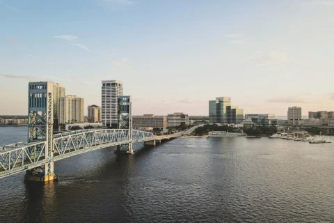jacksonville-fl Downtown Jacksonville, Florida skyline with Main Street Bridge spanning the St. Johns River during sunset.