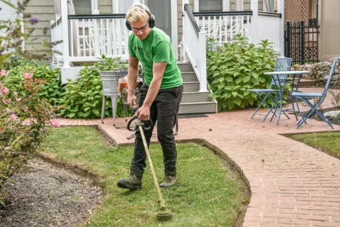 landscaping-website-example-image Green lawn being mowed by an electric push mower during a residential landscaping project