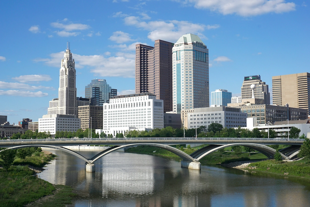 Columbus, Ohio cityscape with LeVeque Tower, skyscrapers, and bridge crossing the Scioto River.