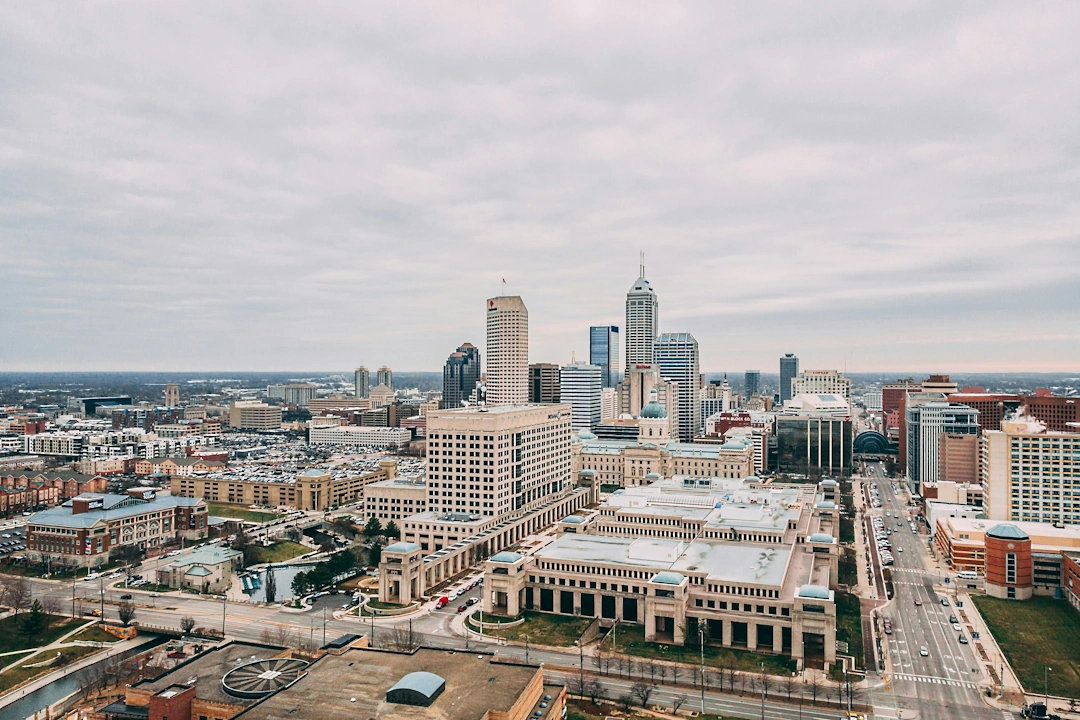 Aerial view of downtown Indianapolis, Indiana with the Indiana Statehouse and city buildings on a cloudy day.