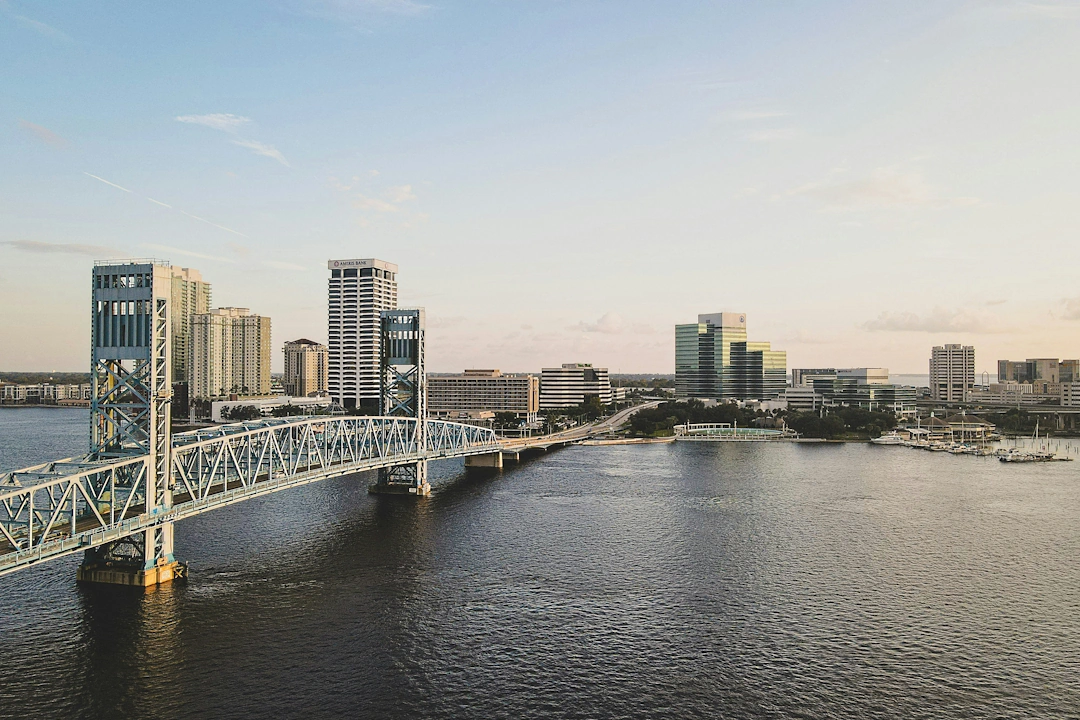 Downtown Jacksonville, Florida skyline with Main Street Bridge spanning the St. Johns River during sunset.