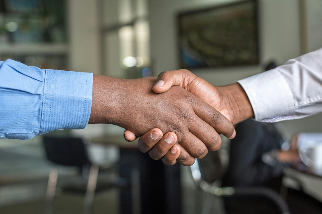 local-services Close-up of two business professionals shaking hands in an office environment symbolizing local services partnership