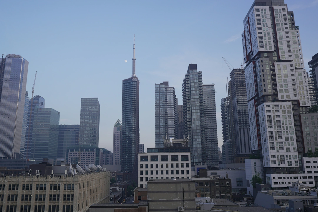 Downtown Toronto skyline with modern high-rise buildings and the CN Tower at dusk.